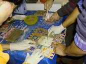 Tutors assisting participants with the grout phase of mosaic making.